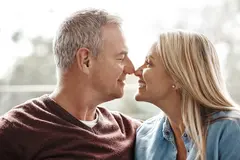 Mature couple smiling and in a nose touch while sitting