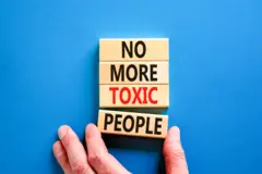 Words 'No more toxic people' on wooden blocks on a blue table background