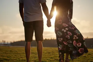 Couple holding hands while watching the sunset