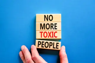 Words 'No more toxic people' on wooden blocks on a blue table background